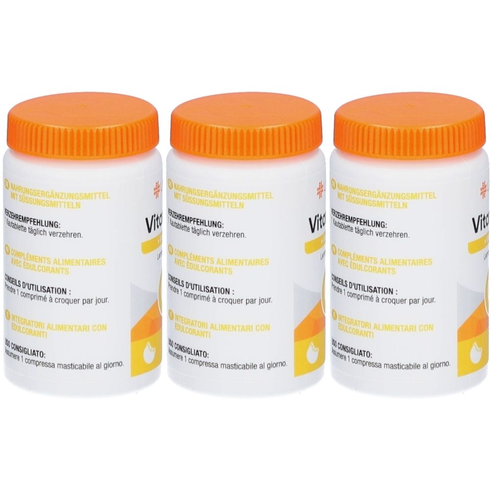 Drei weiße Flaschen mit orangefarbenen Deckeln. Aufschrift: Vitamin. Nahrungsergänzungsmittel. Gebrauchsanweisung in mehreren Sprachen.