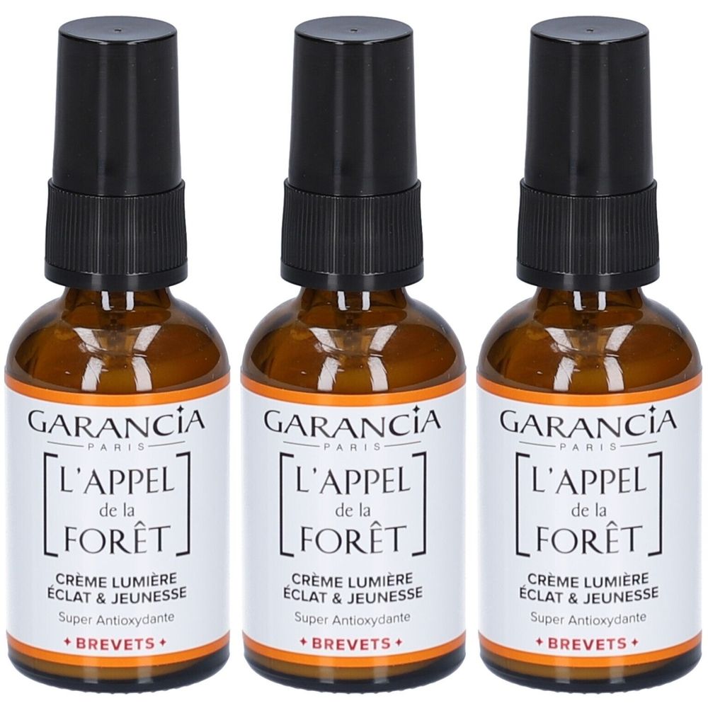 Drei Flaschen GARANCIA Crème Lumière. Braune Glasflaschen mit schwarzem Sprühkopf und weißem Etikett. Text: L'APPEL de la FORÊT.