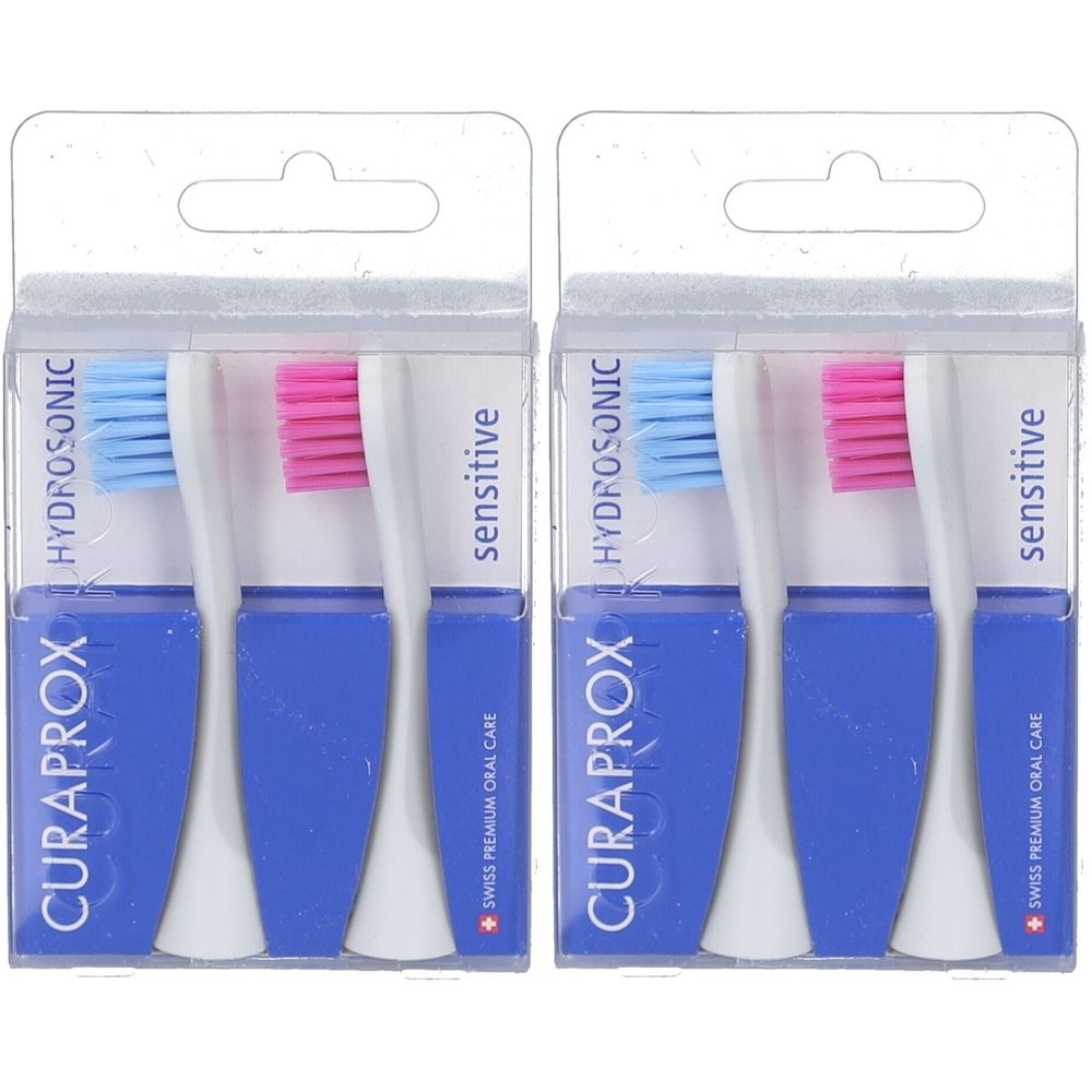 Zwei Packungen mit je zwei Zahnbürstenköpfen. Blaue und rosa Borsten. Verpackung mit CURAPROX-Logo und "sensitive"-Schriftzug.