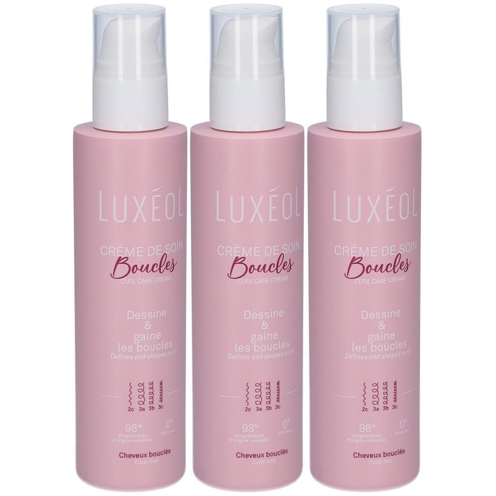Trois flacons roses avec pompe blanche. Inscription: LUXÉOL Crème de Soin Boucles. Texte: Dessine & gaine les boucles.
