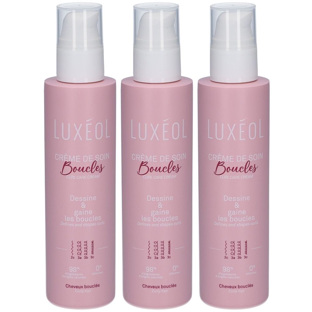 Trois flacons roses avec pompes blanches. Chaque flacon porte la marque LUXÉOL, Crème de Soin Boucles, et d'autres informations.