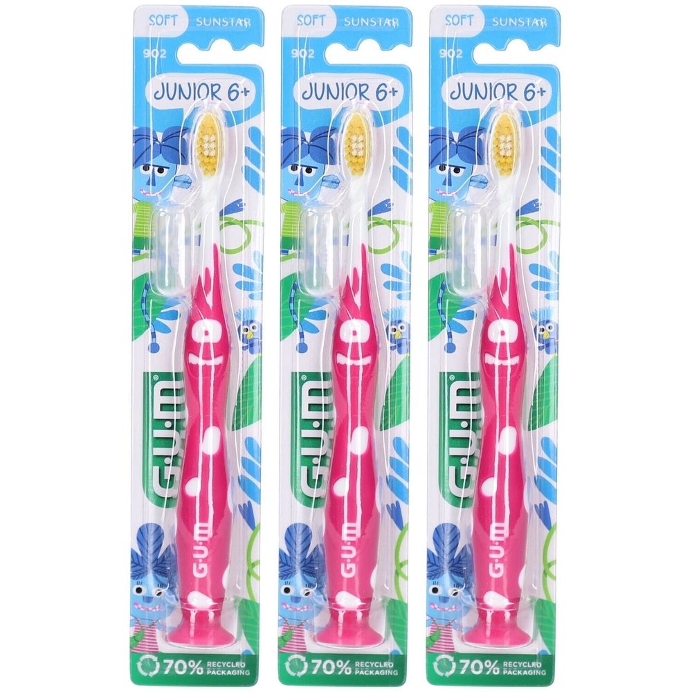 Drei Zahnbürsten für Kinder. Rosa Griff mit weißen Punkten, gelbe Borsten. Verpackung mit Produktnamen und Logo.