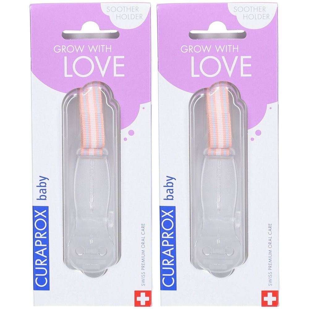 Zwei Baby-Zahnbürsten in Verpackung. Rosa-weißes Bürstenteil, transparenter Griff. Verpackung mit Schriftzug "Grow with Love" und Logo.