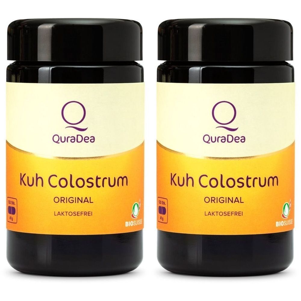 Zwei schwarze Flaschen mit Deckel. Aufschrift: QuraDea Kuh Colostrum Original, laktosefrei. Gelber Hintergrund mit Logo und Siegel.