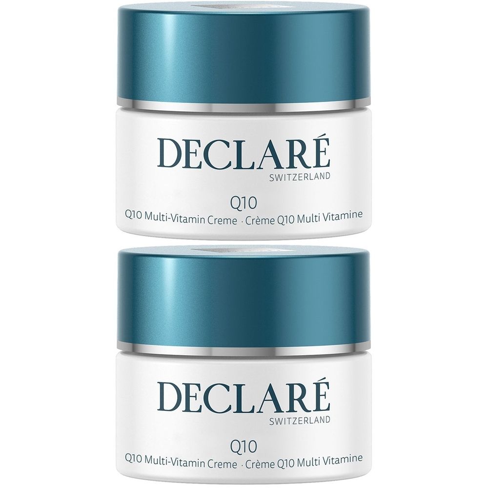 Deux pots de crème avec couvercles bleus. Inscription: DECLARÉ SWITZERLAND, Q10 Multi-Vitamin Crème. Récipient blanc avec couvercle bleu.