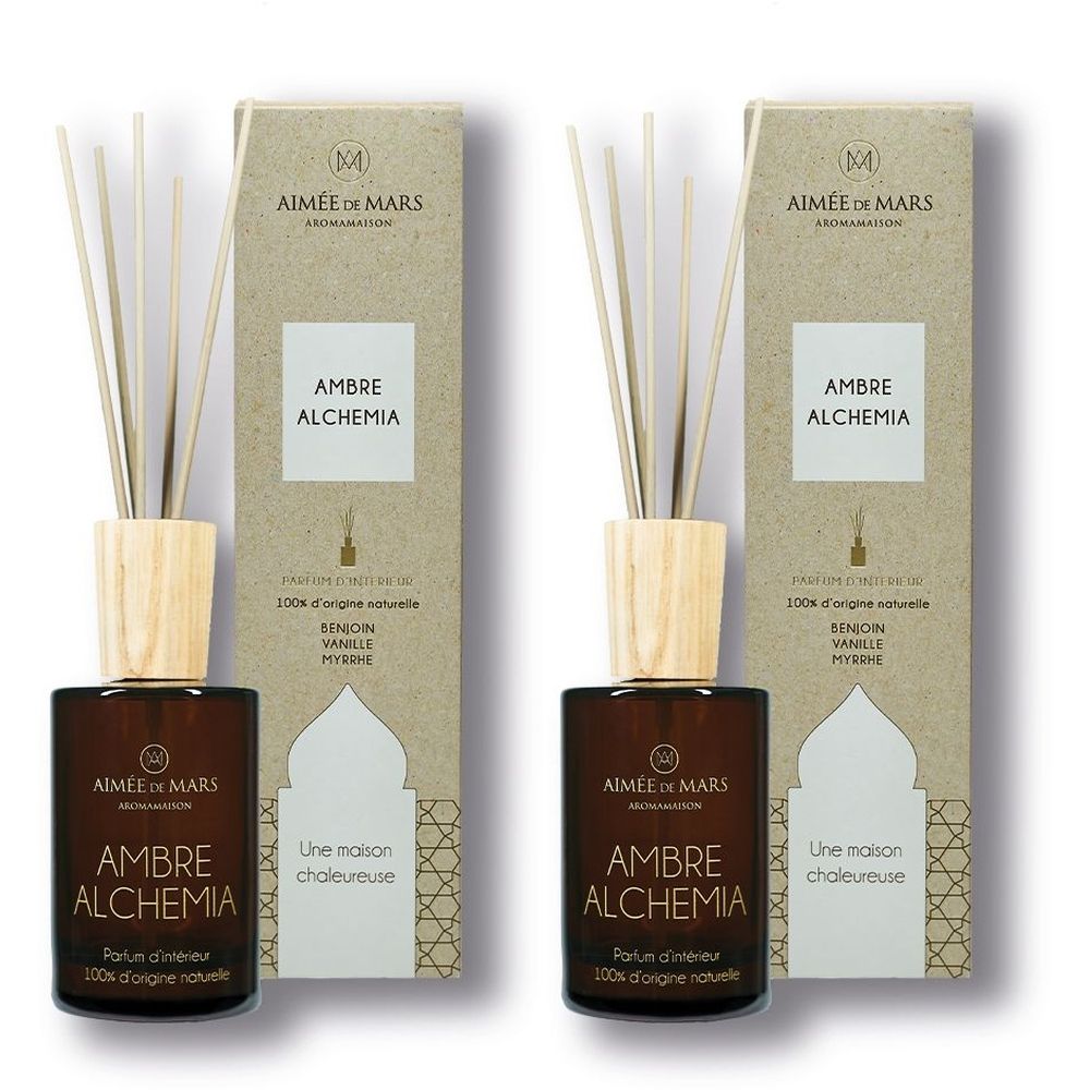 Zwei Raumduftflaschen mit Holzdeckel und Stäbchen. Kartonverpackung mit Produktnamen und Logo. Text: Ambre Alchemia.