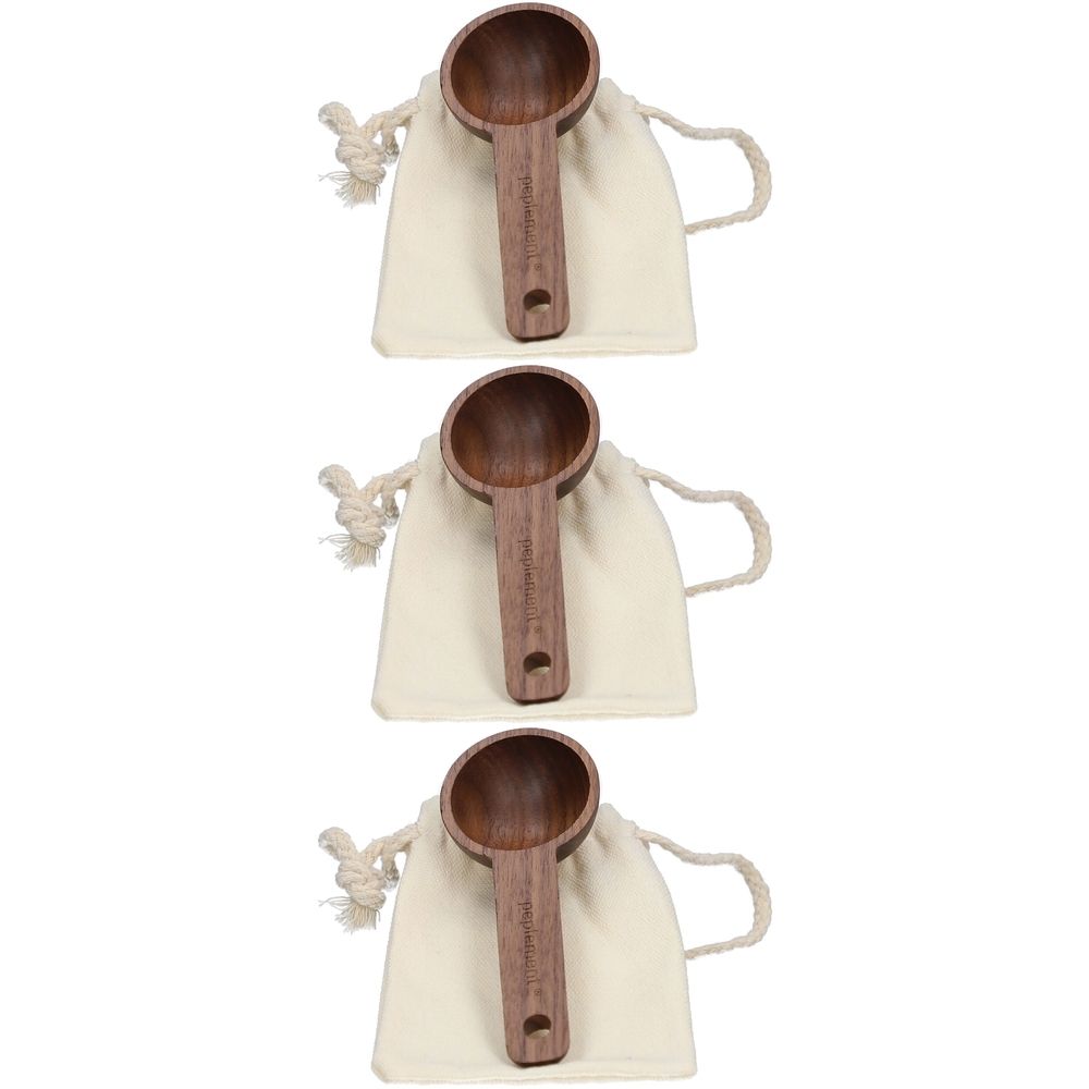 Drei Holzlöffel mit rundem Löffelteil und Loch im Griff, in beigen Stoffbeuteln mit Kordelzug.