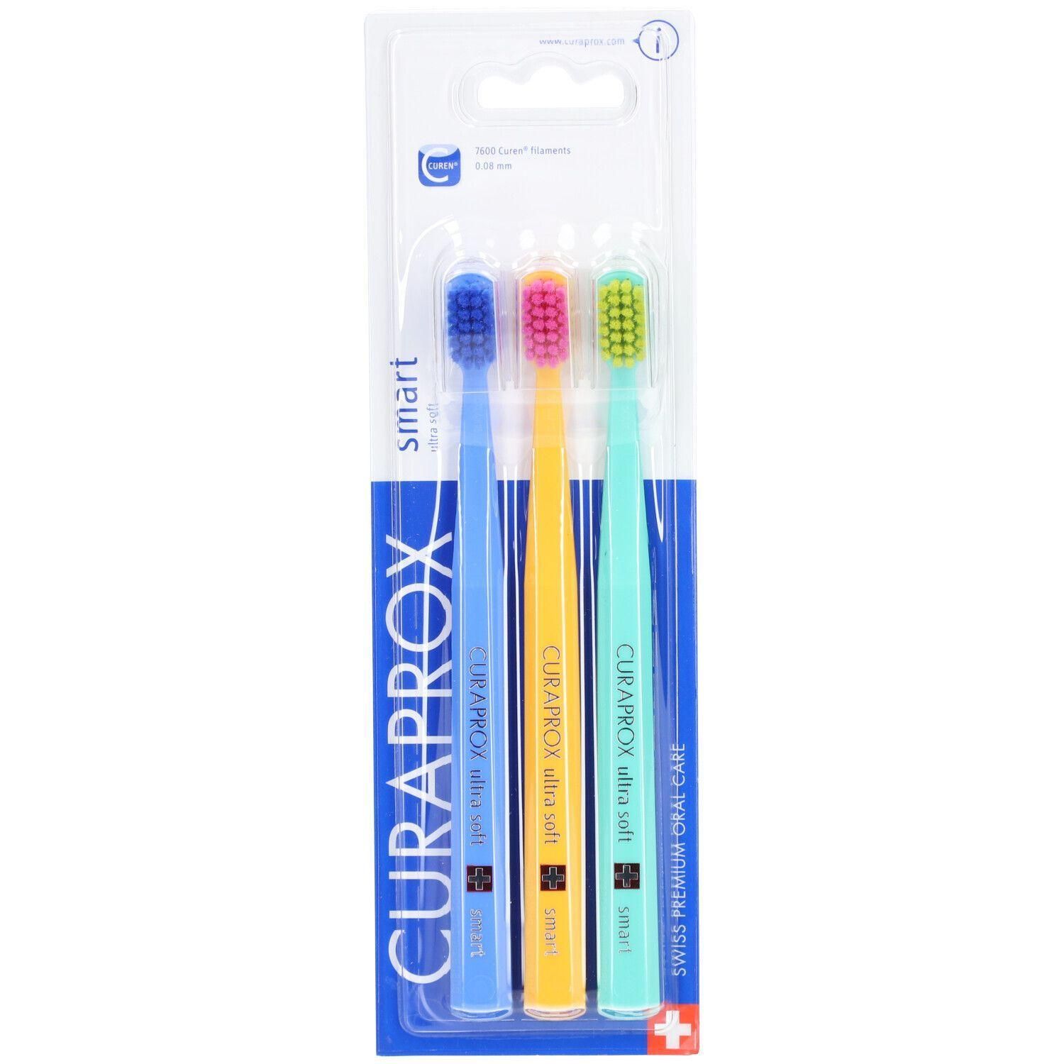 Trois brosses à dents dans un emballage blister. Manches bleues, jaunes et vertes. Inscription : CURAPROX, ultra soft, smart. Soins bucco-dentaires suisses.