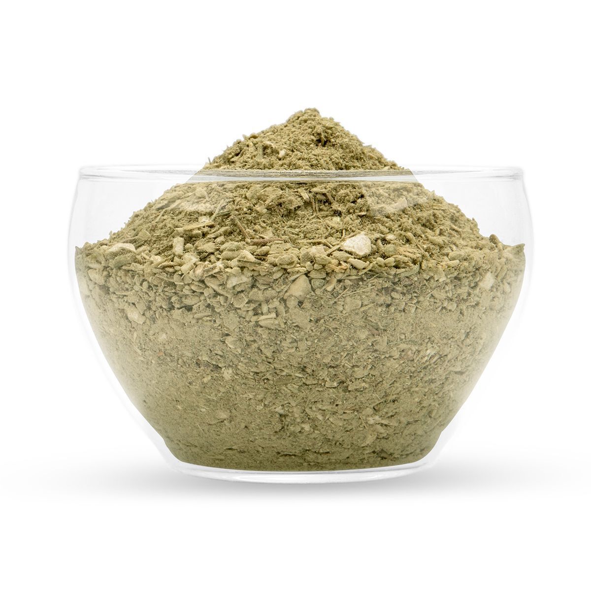 Bol en verre transparent rempli de poudre verdâtre. Le contenu est granuleux et de structure irrégulière.