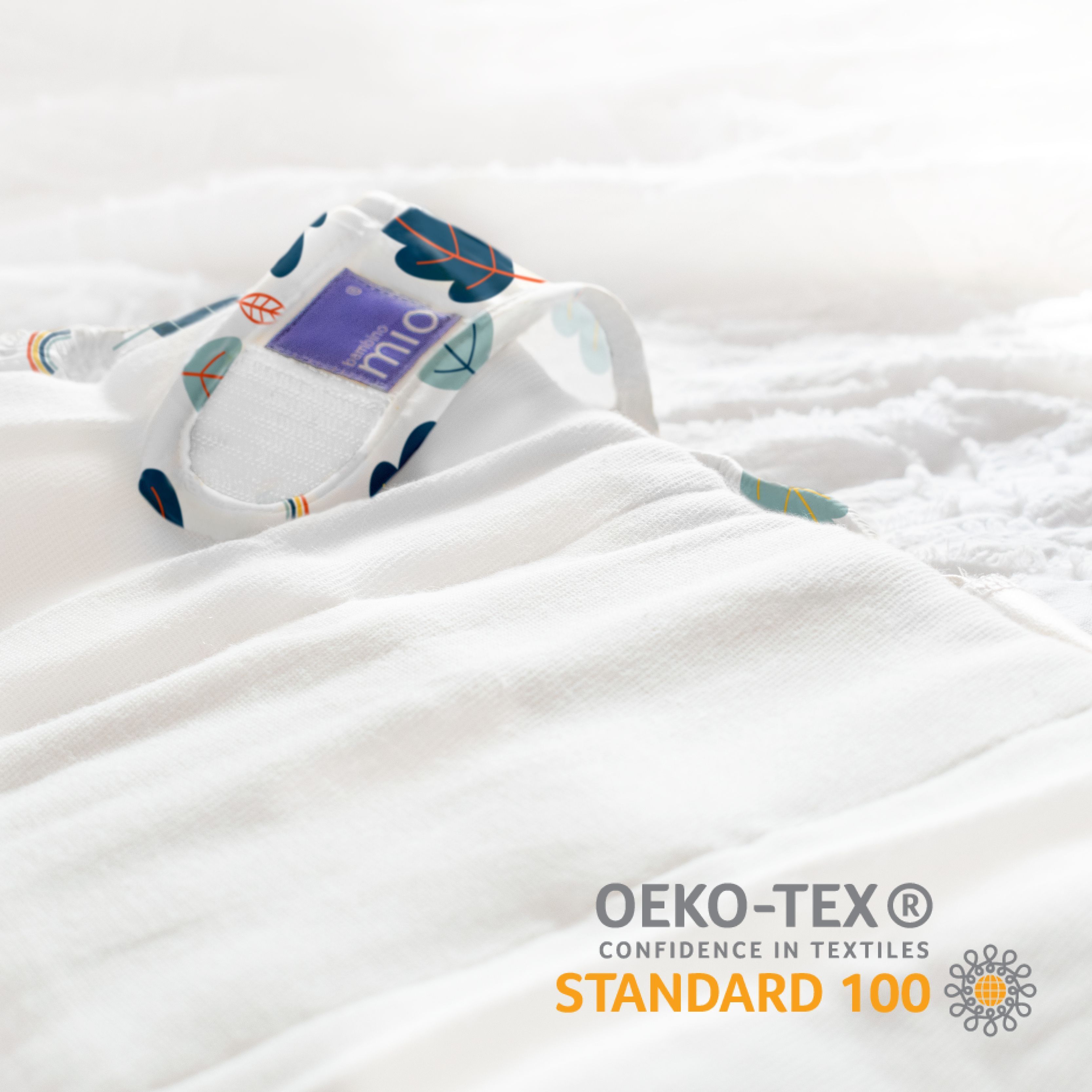 Couche lavable avec motif de feuilles. Texte : Oeko-Tex Standard 100.