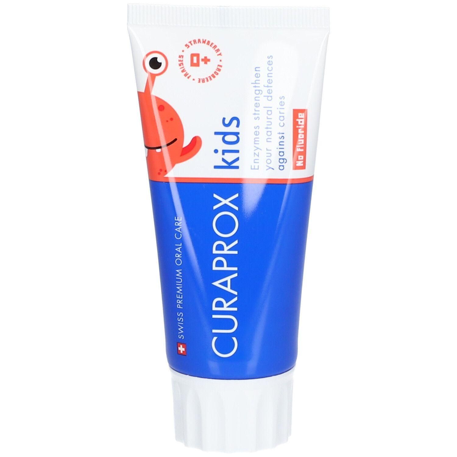 Tube de dentifrice blanche et bleue avec personnage de dessin animé rouge. Inscription: CURAPROX kids, No Fluoride. Goût fraise.
