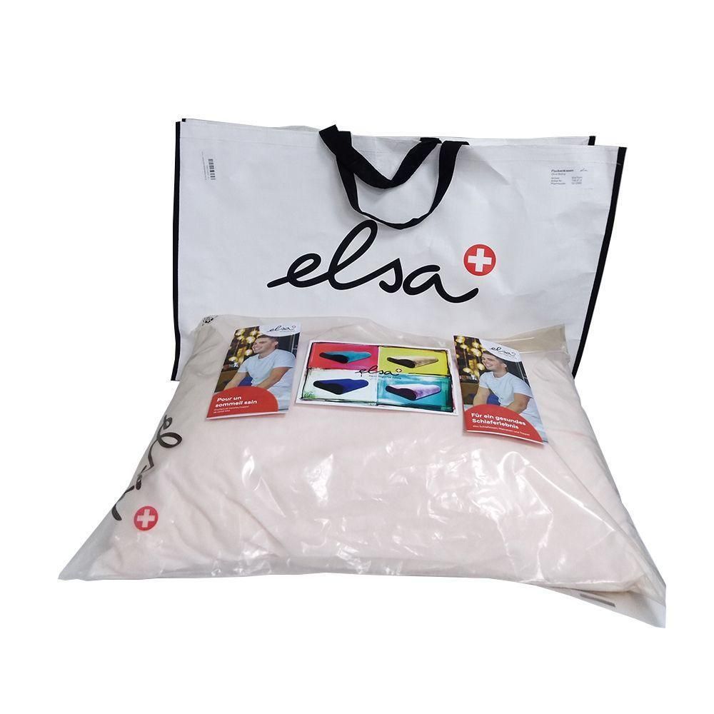 Oreiller dans un emballage plastique, sous un sac avec le logo "elsa" et une croix rouge. Des flyers sont attachés à l'oreiller.