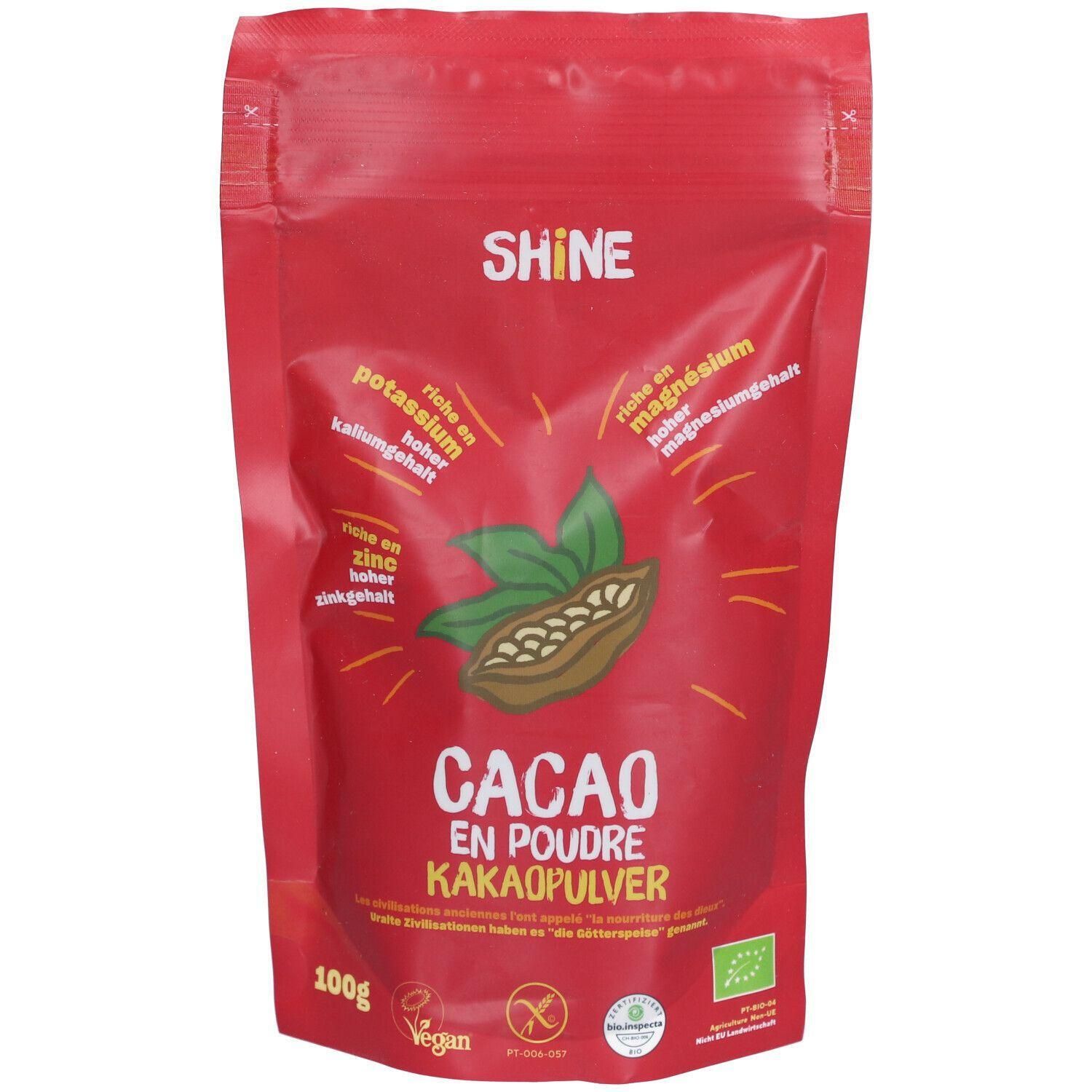 Rote Verpackung mit SHINE-Logo und Cacao-Pulver-Aufschrift. Enthält Kakao, Zink, Magnesium und Kalium. Vegan, Bio-Zertifizierung.