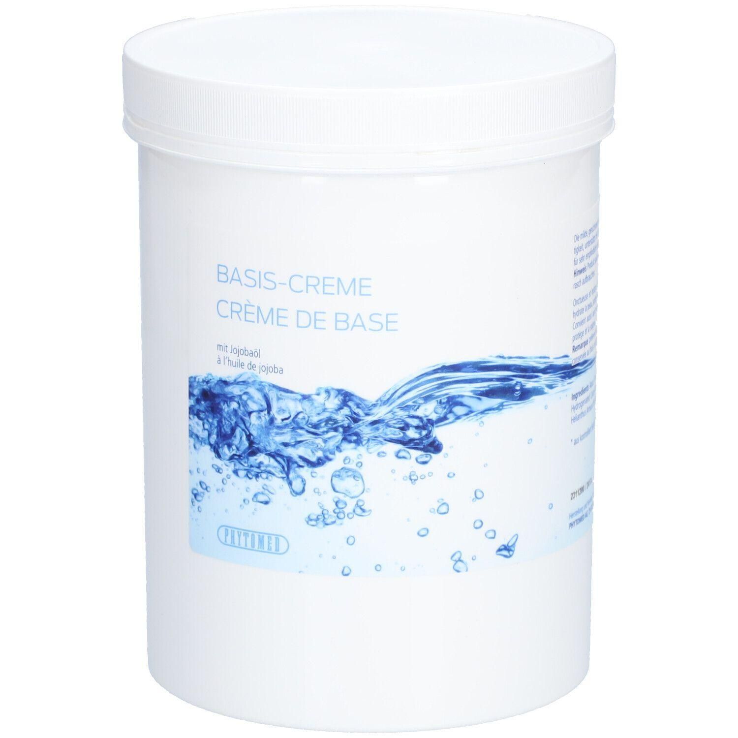 Weißer Tiegel mit Deckel. Aufschrift: BASIS-CREME, CRÈME DE BASE, mit Jojobaöl. Wasser-Motiv auf dem Etikett.
