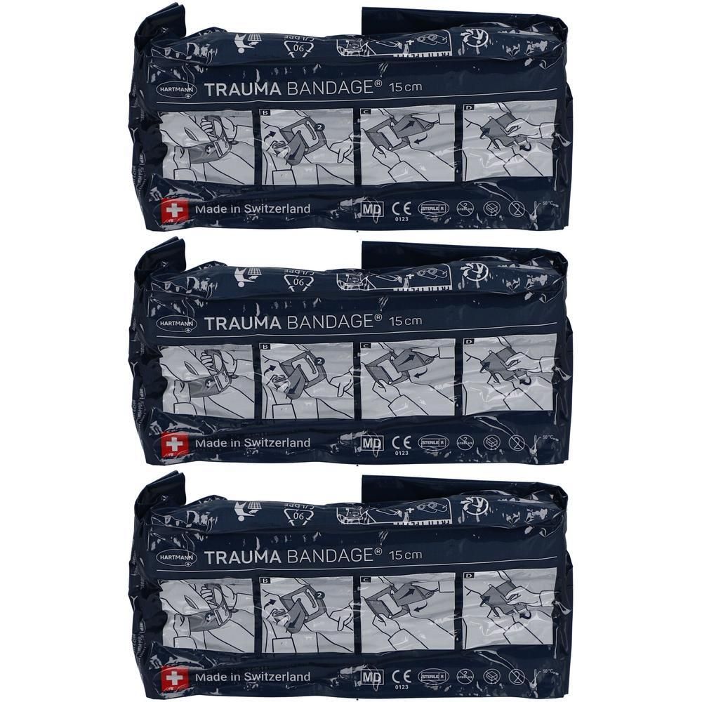 Drei verpackte Trauma Bandagen. Dunkelblaue Verpackung mit weißer Schrift. Aufschrift: TRAUMA BANDAGE 15cm. Hergestellt in der Schweiz. CE-Kennzeichnung.