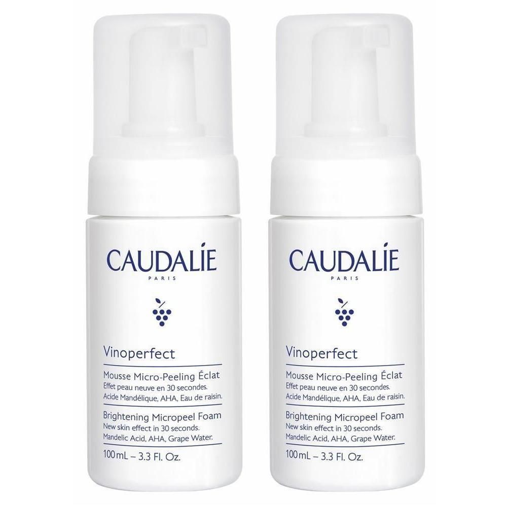Zwei weiße Flaschen mit Sprühkopf. Aufschrift CAUDALIE, Vinoperfect, Mousse Micro-Peeling Éclat. Text in Französisch und Englisch.