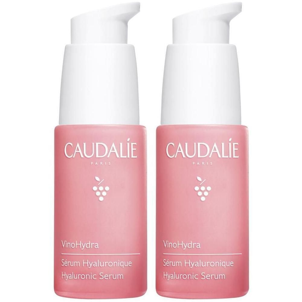 Zwei rosa Flaschen mit weißen Pumpköpfen. Auf jeder Flasche steht CAUDALIE, VinoHydra, Sérum Hyaluronique, Hyaluronic Serum.