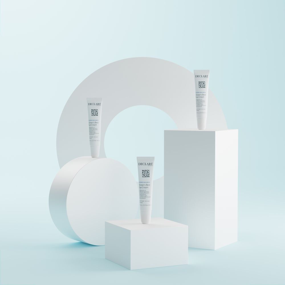 Quatre tubes de crème contour des yeux DECLARÉ Hydro Balance sur des piédestaux géométriques blancs.