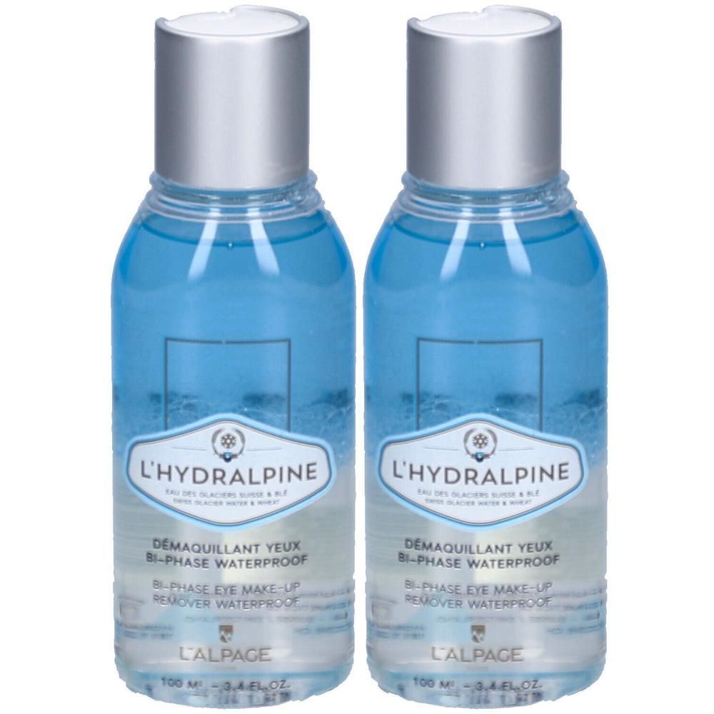 Zwei Flaschen L'Hydralpine Augen-Make-up-Entferner. Blaue Flüssigkeit in transparenten Flaschen mit silbernen Deckeln. Text: L'ALPAGE, DEMAQUILLANT YEUX.