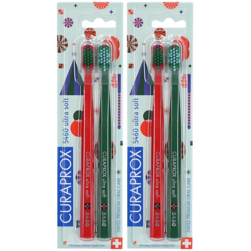 Zwei Curaprox Zahnbürsten, rot und grün, 5460 ultra soft, in Weihnachts-Edition-Verpackung.