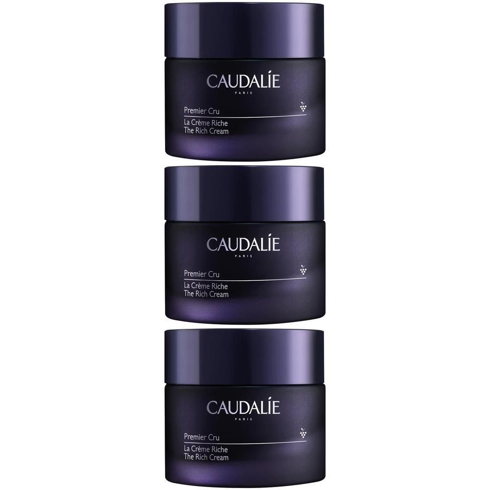 Drei Tiegel Creme, dunkelblau mit Deckel. Aufschrift CAUDALIE, Premier Cru, La Crème Riche, The Rich Cream. Auf weißem Hintergrund.