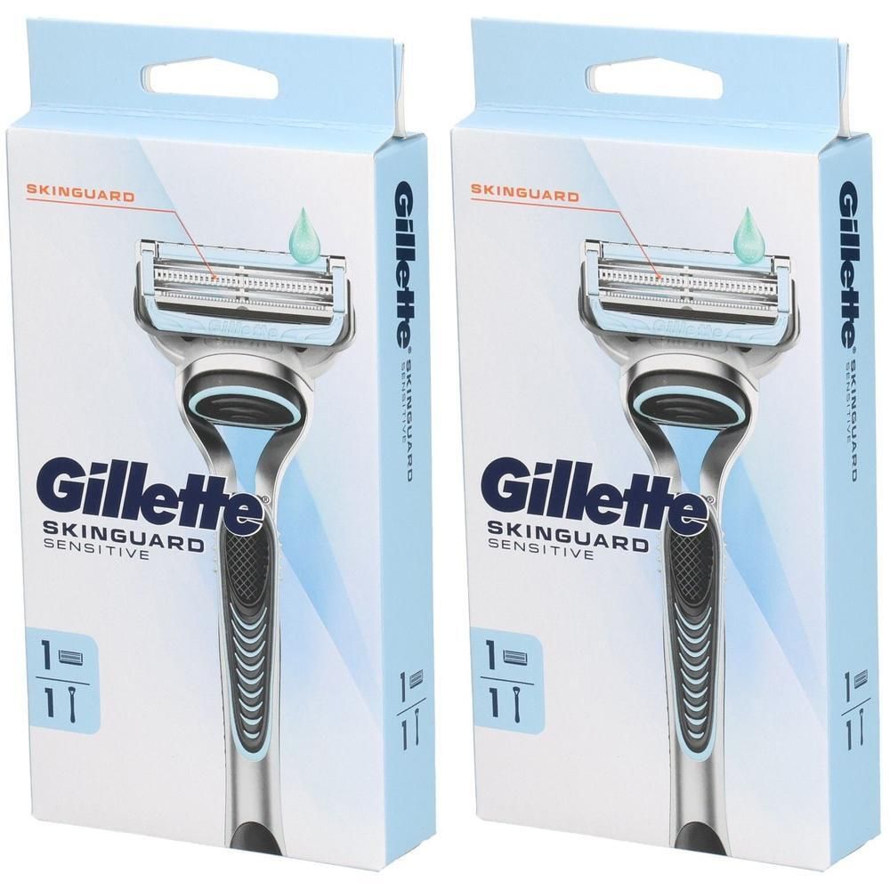 Deux rasoirs dans leur emballage. Marque Gillette SkinGuard Sensitive. Emballage bleu clair avec image du rasoir et nom du produit.