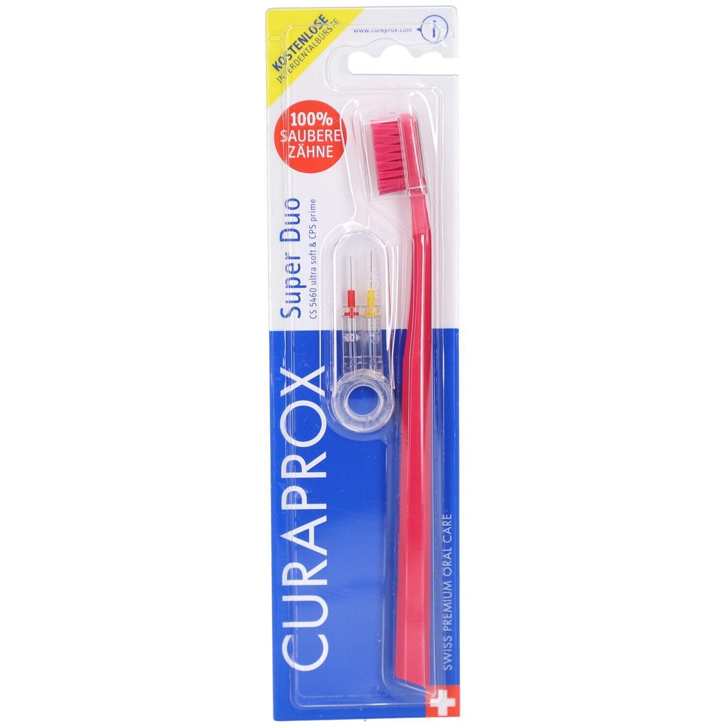 Brosse à dents et support dans un emballage. Brosse à dents rouge, support transparent avec éléments colorés. Emballage bleu avec le texte CURAPROX.