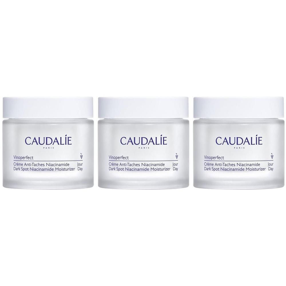 Trois pots de crème en verre blanc avec couvercle blanc. Inscription: CAUDALIE, Vinoperfect, Crème Anti-Taches Niacinamide, Dark Spot Niacinamide Moisturizer.
