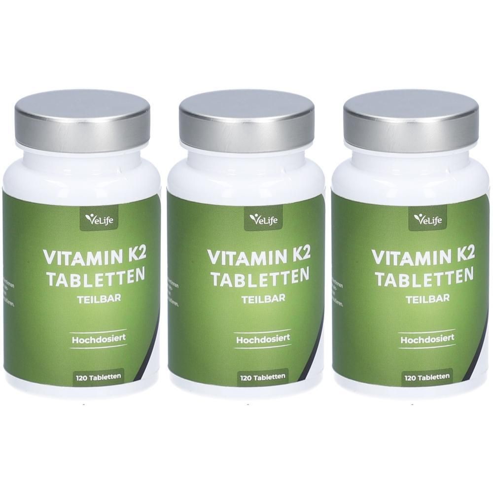 Drei weiße Flaschen mit silbernen Deckeln. Auf jeder Flasche steht "Vitamin K2 Tabletten" und "VeLife".