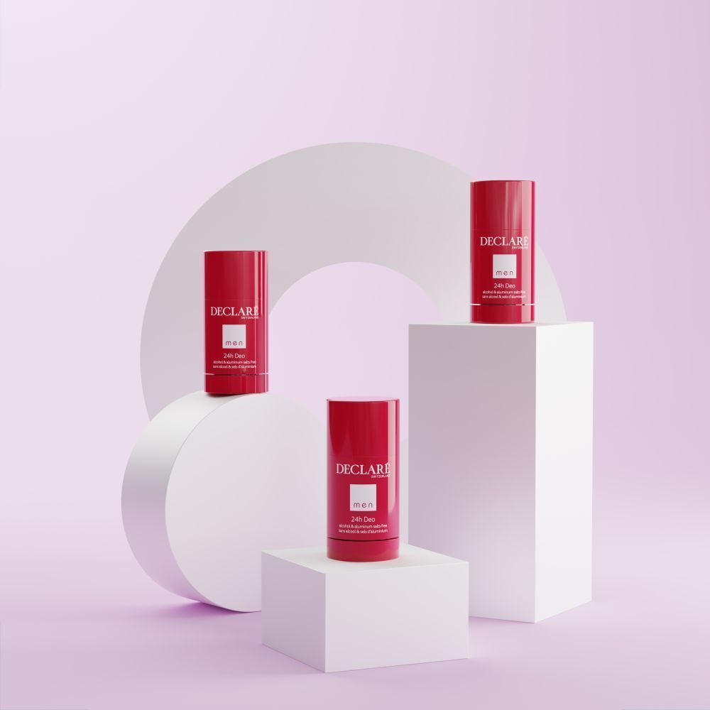 Trois sticks déodorants rouges sur socles blancs. DECLARÉ, Switzerland, men, 24h Deo. Fond avec cercle blanc.