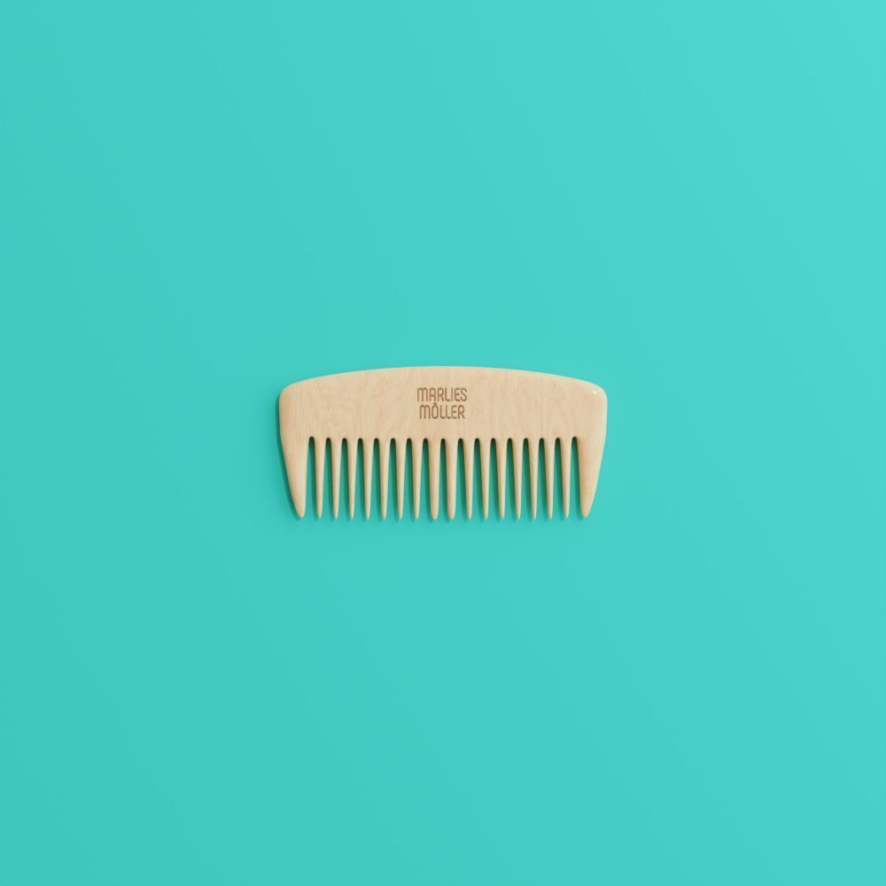 Peigne en bois à dents larges sur fond turquoise. Le peigne a une poignée arrondie.
