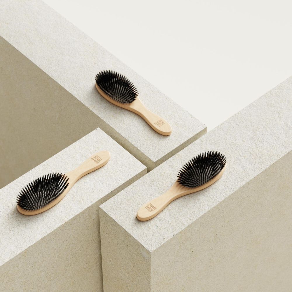 Trois brosses avec manche en bois sur des blocs blancs. Soies noires. "Marlies Möller" sur le manche.