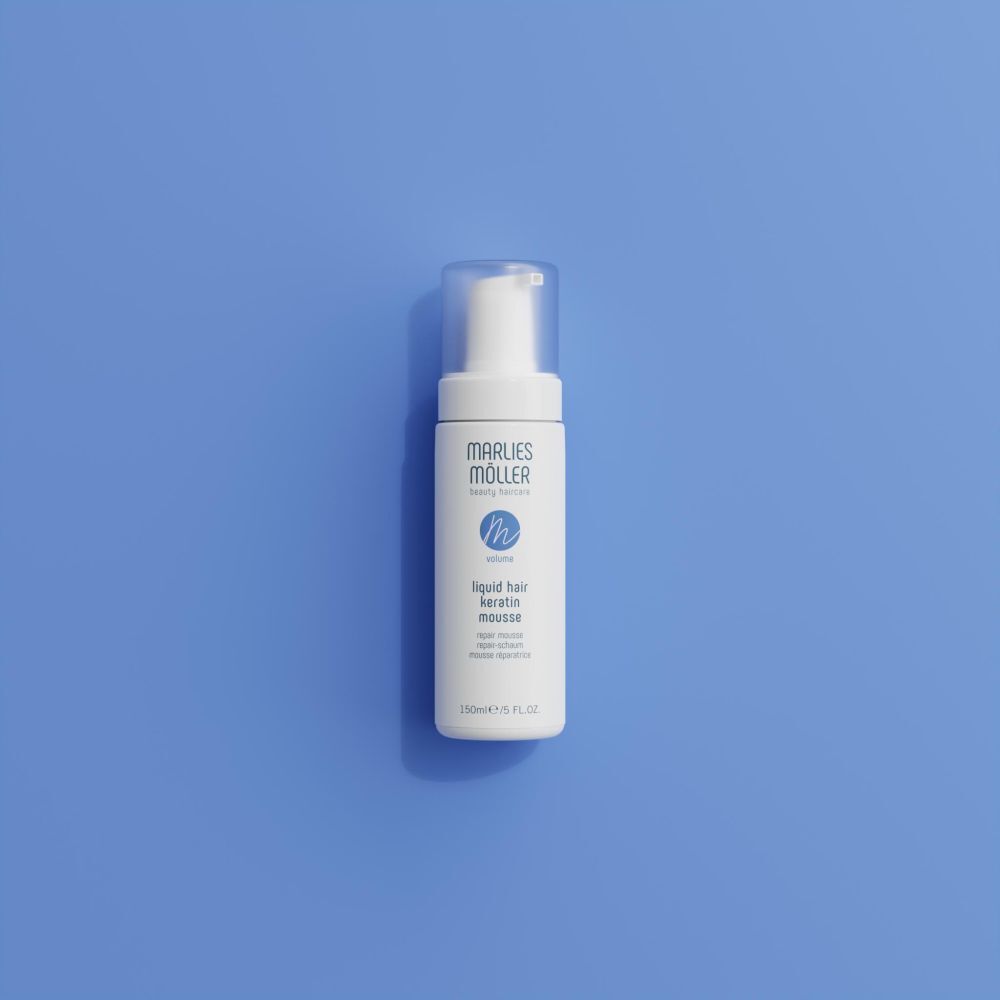 Weiße Flasche mit Sprühkopf auf blauem Hintergrund. Aufschrift: Marlies Möller, Liquid Hair Keratin Mousse. 150ml/5 FL.OZ.