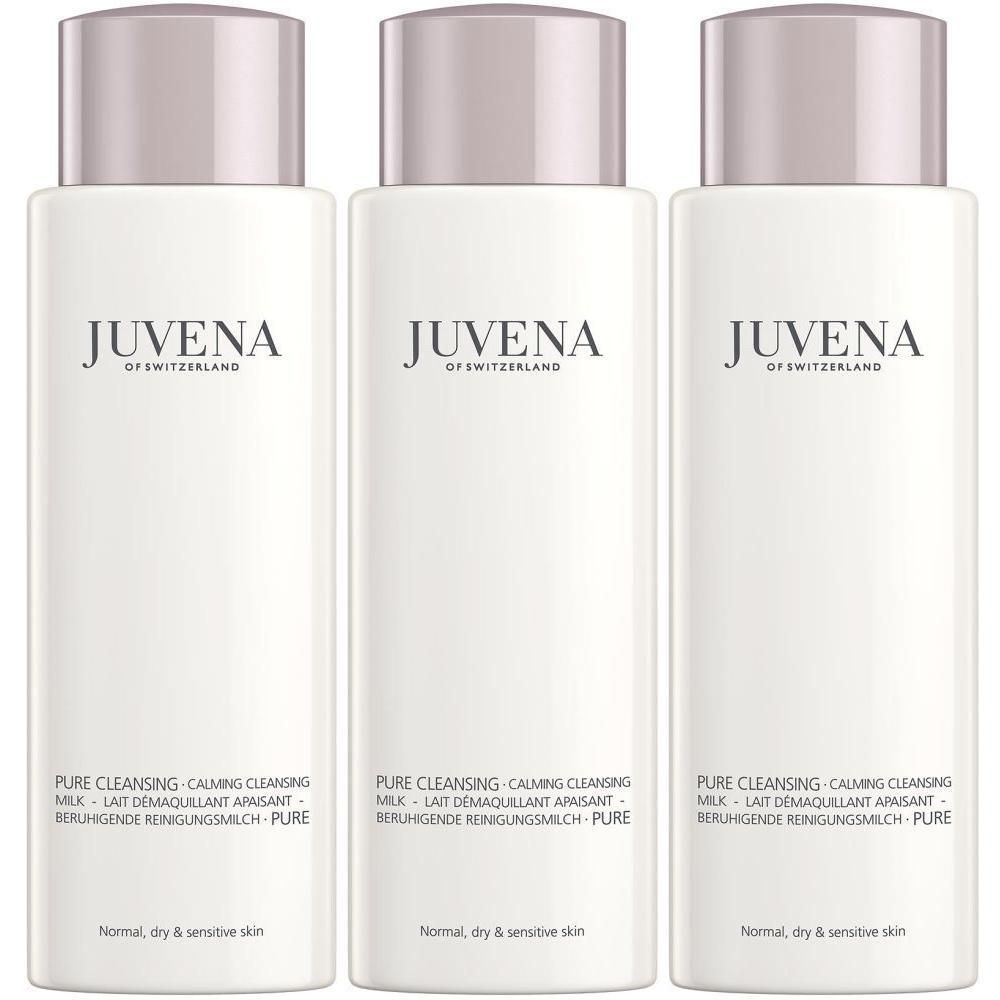 Trois flacons blancs de Juvena Calming Cleansing Milk avec bouchon rose. Étiquetage en allemand et anglais.