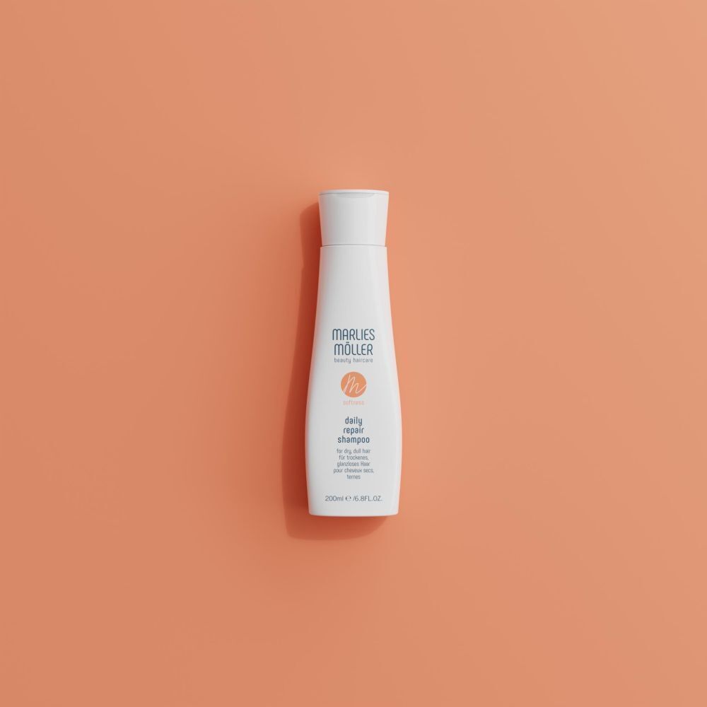 Weiße Flasche mit weißem Deckel. Aufschrift: Marlies Möller, daily repair shampoo. Auf orangefarbenem Hintergrund.