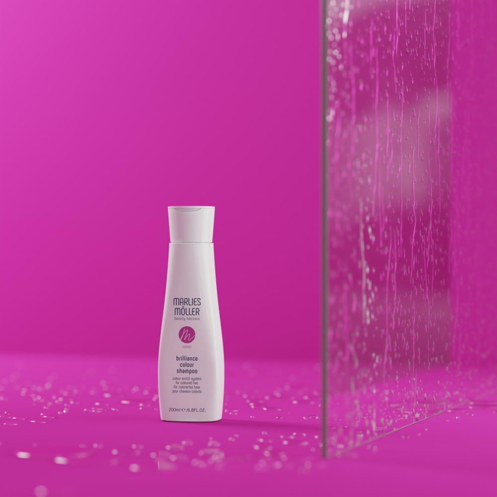 Weiße Shampoo-Flasche vor pinkfarbenem Hintergrund. Aufschrift: Marlies Möller, Brilliance Colour Shampoo. Für coloriertes Haar.