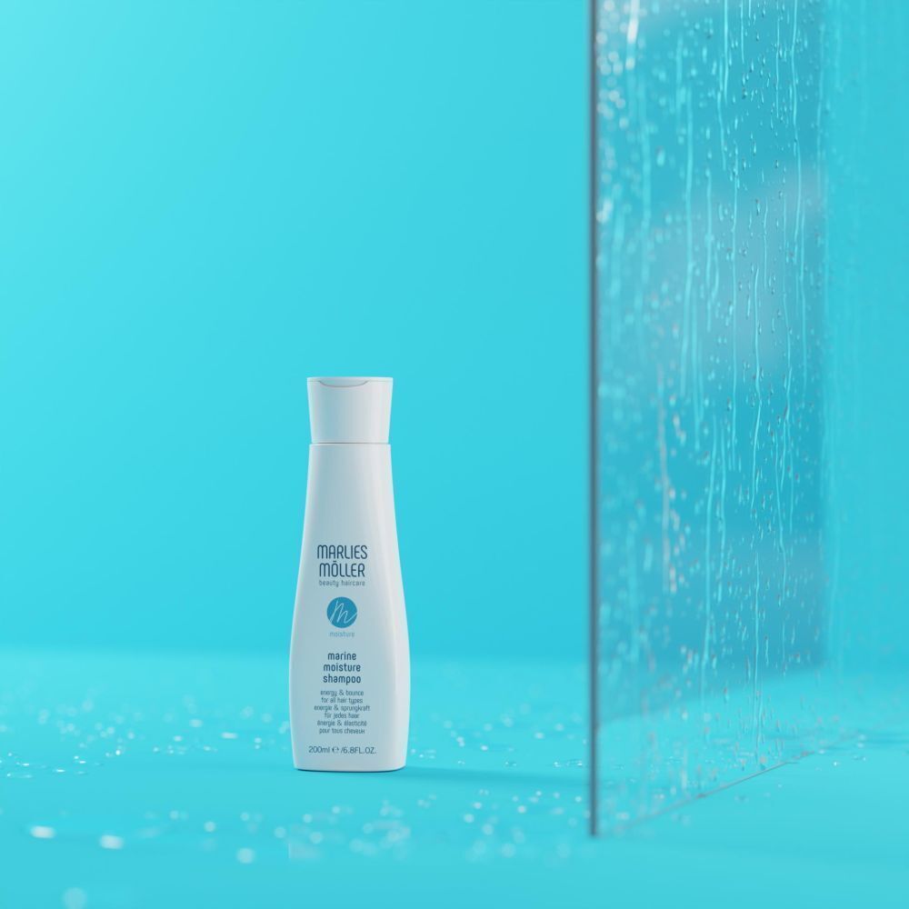 Eine weiße Shampoo-Flasche vor blauem Hintergrund und Glas. Aufschrift: Marlies Möller, marine moisture shampoo. 200ml / 6.8FL.OZ.