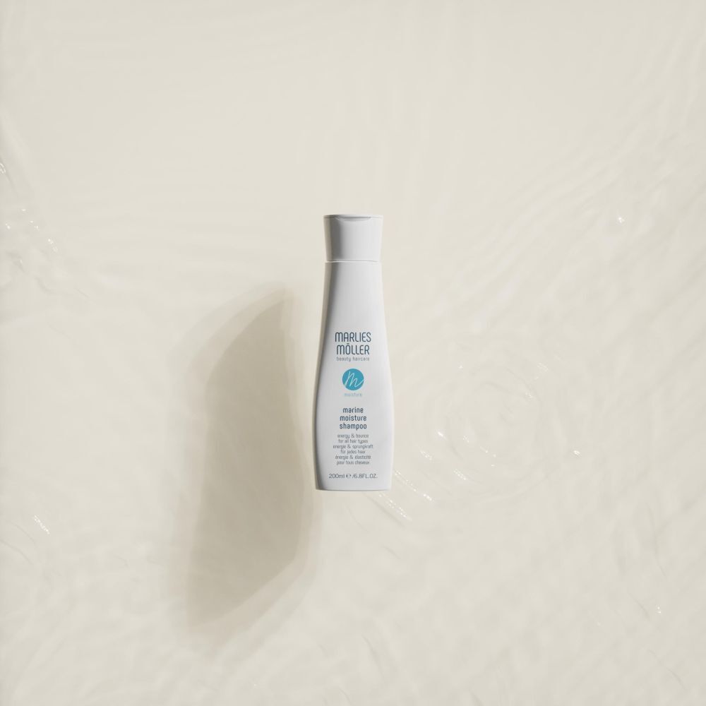 Eine weiße Shampoo-Flasche auf hellem Hintergrund. Auf der Flasche steht "Marlies Möller" und "marine moisture shampoo".