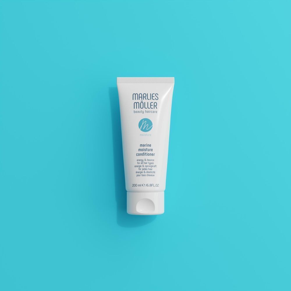 Eine Tube Marlies Möller Marine Moisture Conditioner auf einem blauen Hintergrund.