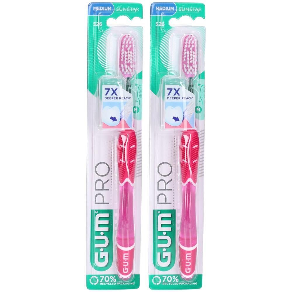 Deux brosses à dents emballées. Manche rose, poils blanc-rose. Inscriptions : G.U.M PRO, 7X deeper reach, 70% emballage recyclé.