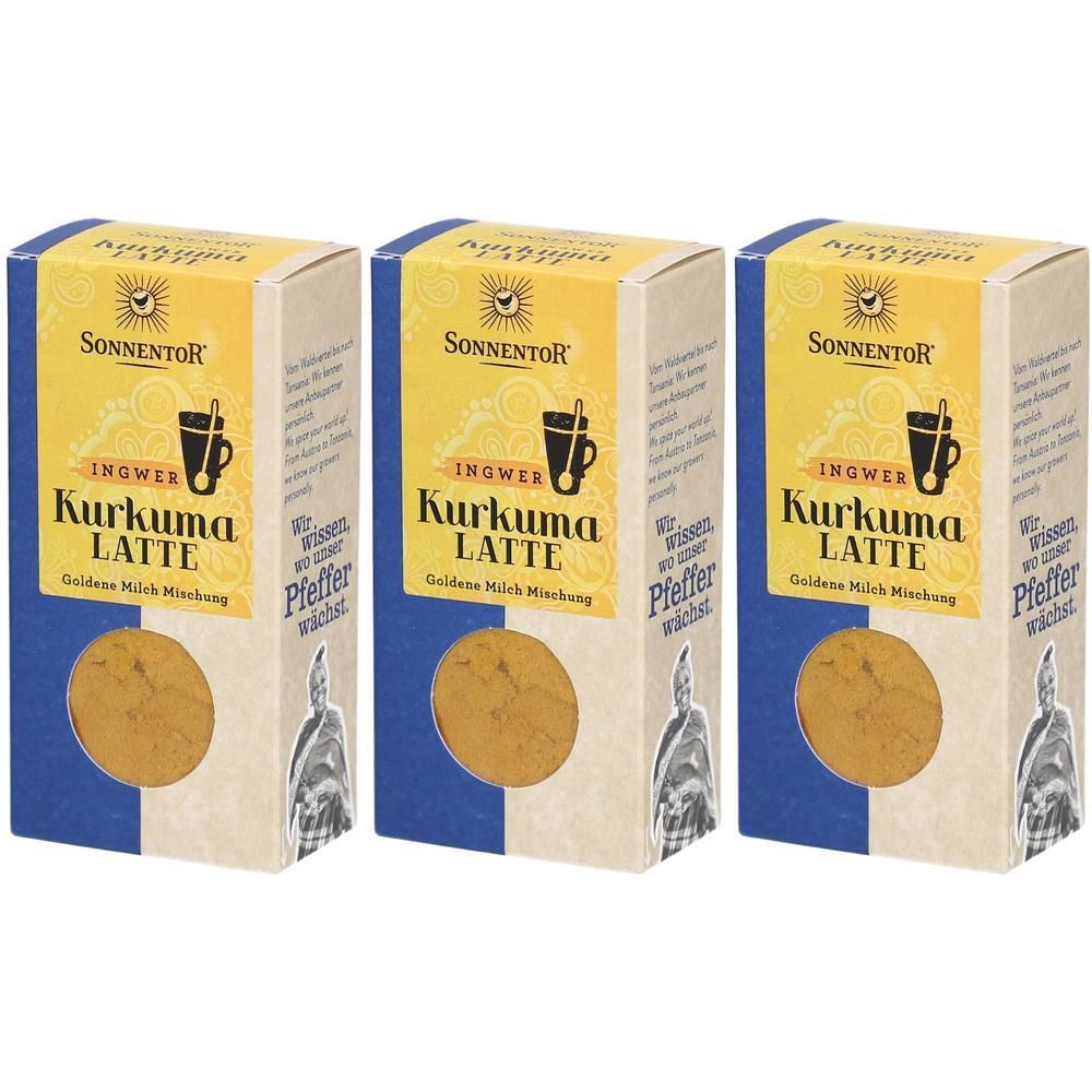 Trois boîtes de SONNENTOR Kurkuma Latte Ingwer. Emballage jaune et bleu avec nom et logo du produit. Fenêtre avec contenu visible.