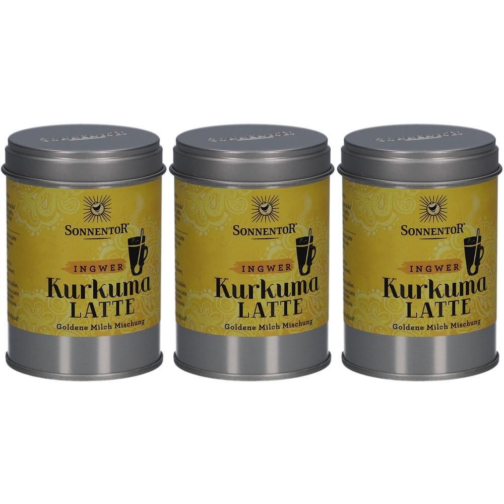 Drei Dosen SONNENTOR Kurkuma Latte Ingwer. Graue Deckel, gelbe Etiketten mit Schriftzug und Logo.