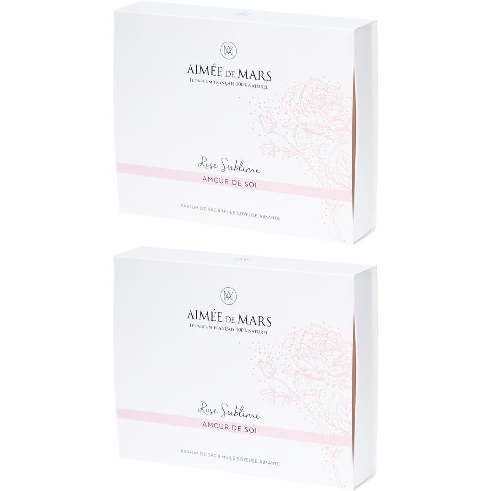 Zwei weiße Kartons mit rosa Akzenten. Aufschrift: AIMÉE DE MARS, Rose Sublime, AMOUR DE SOI. Französisches Parfüm.