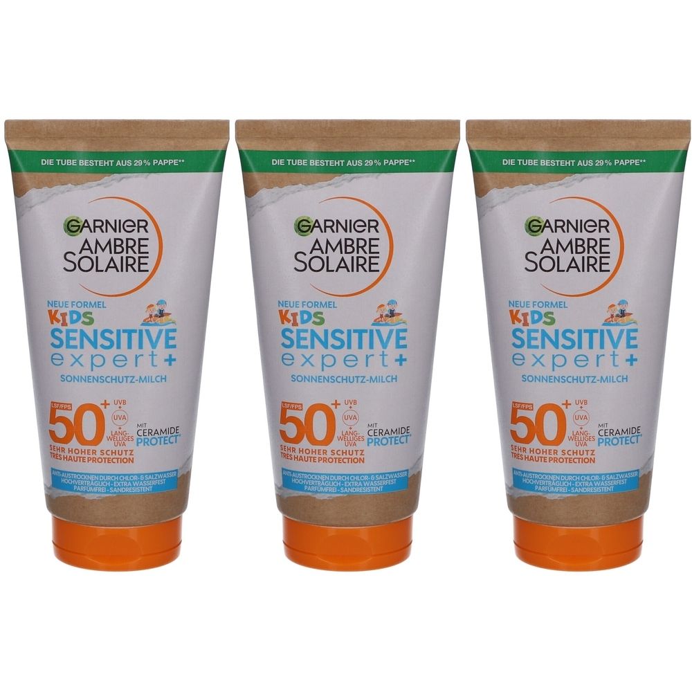 Drei Tuben Garnier Ambre Solaire Kids Sensitive Expert+ Sonnenmilch. Weiße Tuben mit orangefarbenem Deckel, SPF 50.
