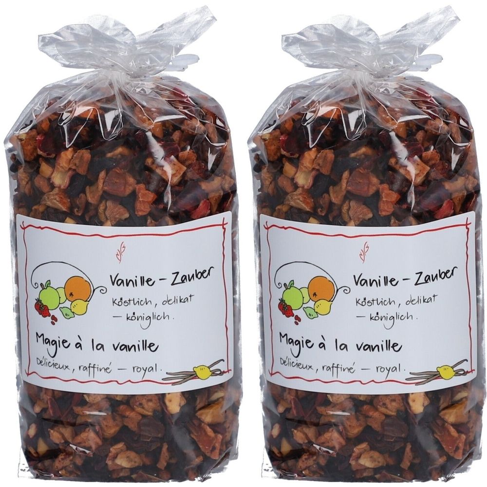 Zwei Beutel Früchtetee. Aufdruck: Vanille-Zauber, Magie à la vanille. Transparente Verpackung mit Inhalt aus getrockneten Früchten.