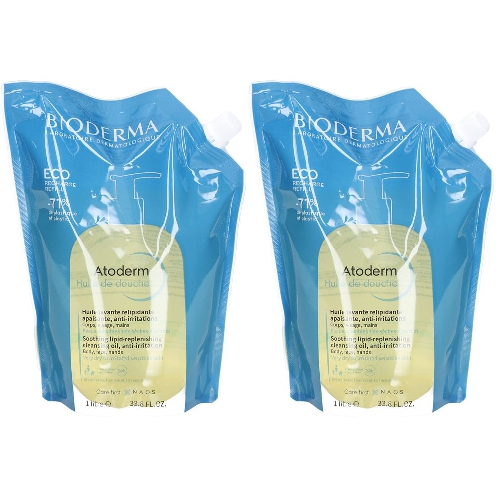 Zwei Nachfüllpackungen Bioderma Atoderm Huile de Douche. Blaue Verpackung mit weißem Verschluss. Gelbe Flüssigkeit sichtbar.