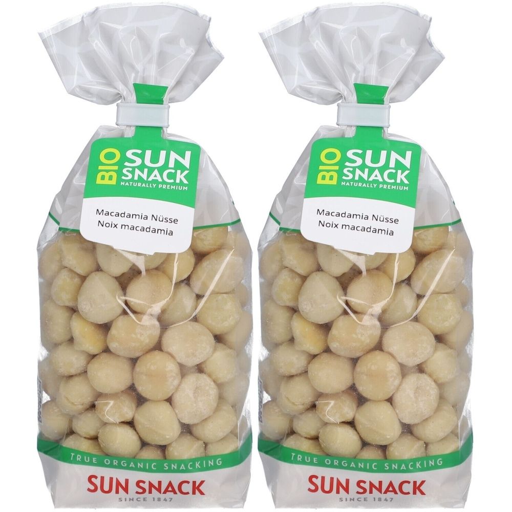 Zwei Beutel mit Macadamia-Nüssen. Klare Verpackung mit Etikett. Aufschrift: BIO SUN SNACK, Macadamia Nüsse, Noix macadamia.