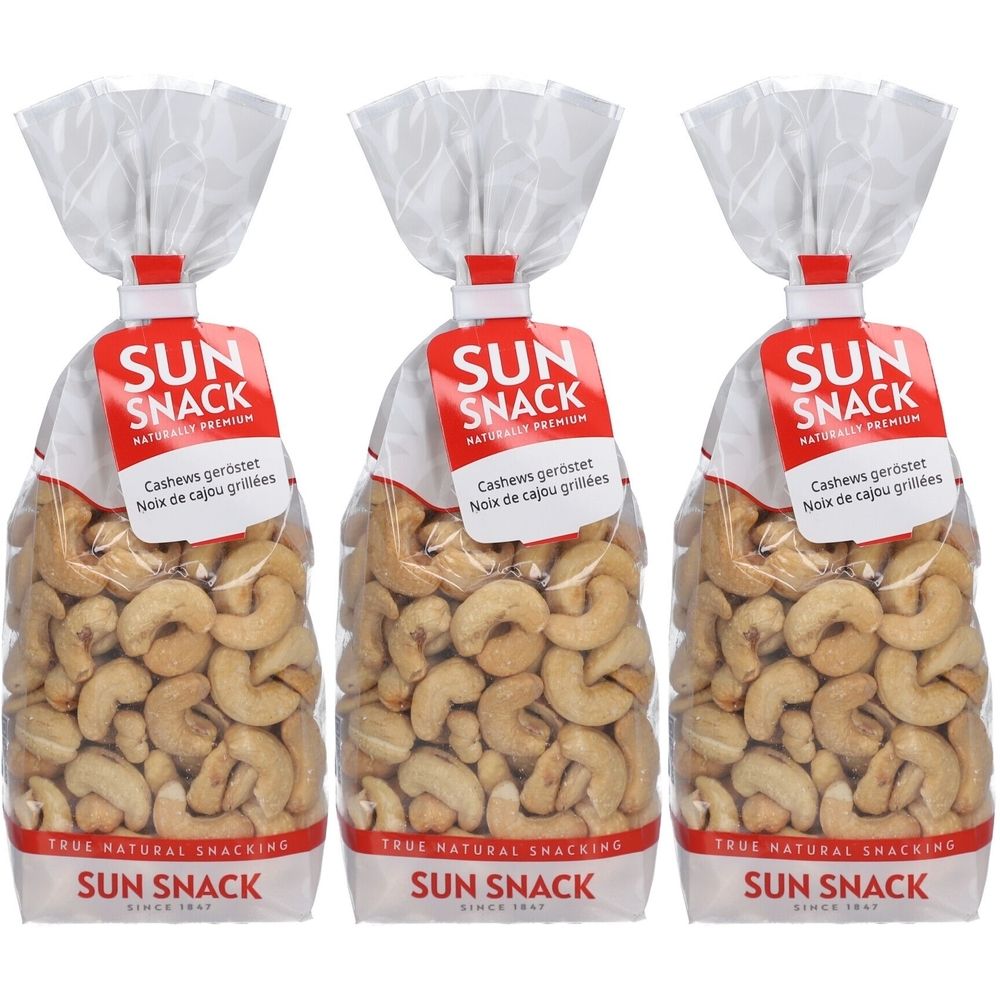 Trois sachets de SUN SNACK noix de cajou. Sacs transparents avec étiquette rouge. Texte: Cashews geröstet, Noix de cajou grillées.