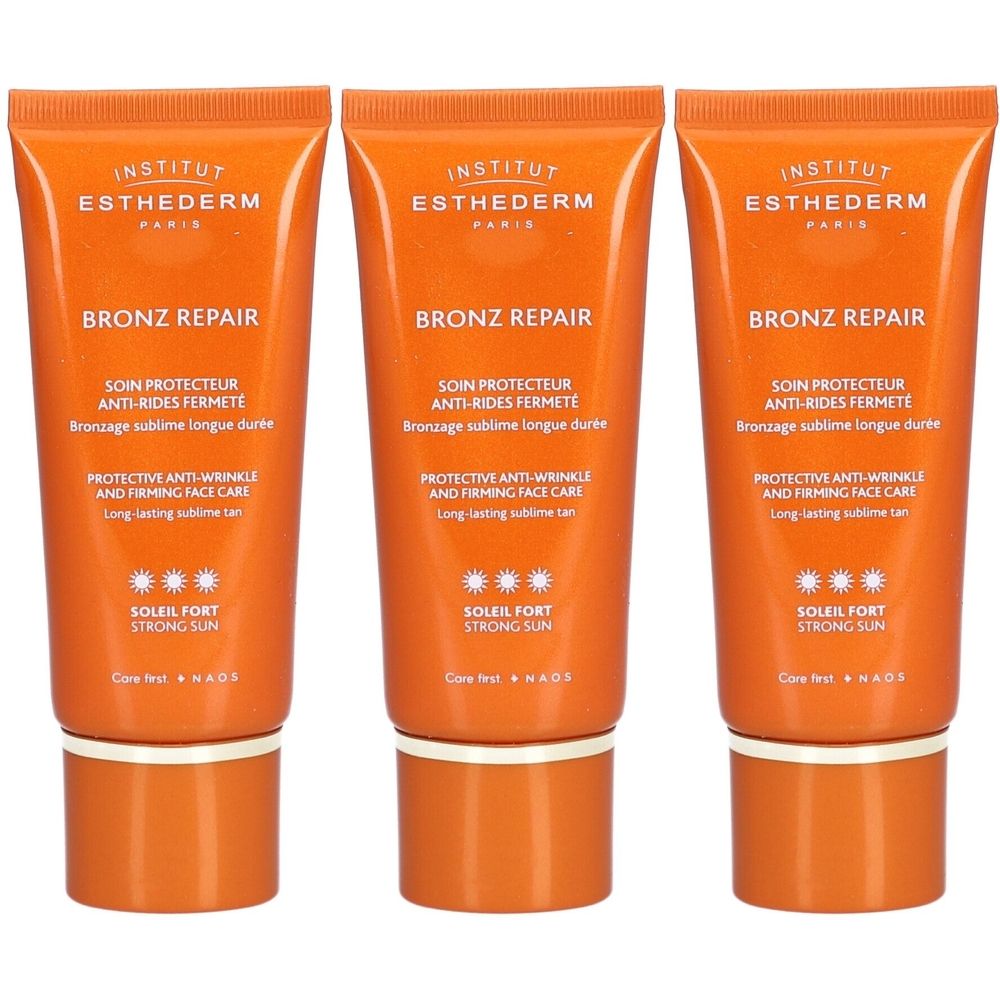 Drei Tuben Sonnencreme. Orangefarbene Verpackung mit weißer Schrift. Text: Bronz Repair, Soleil Fort, Anti-Falten-Pflege.