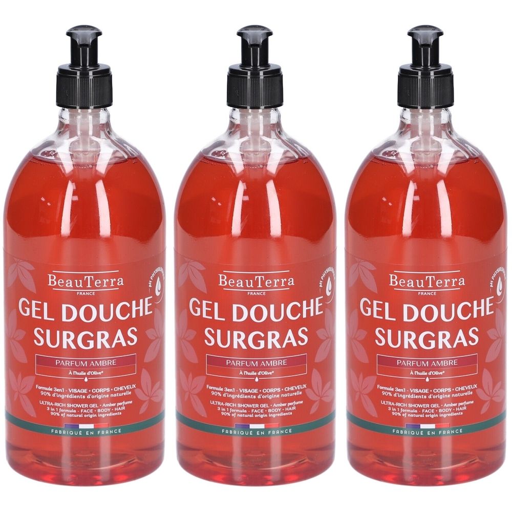 Trois flacons de gel douche avec pompe noire. Inscription: BeauTerra, Gel Douche Surgras, Parfum Ambre.